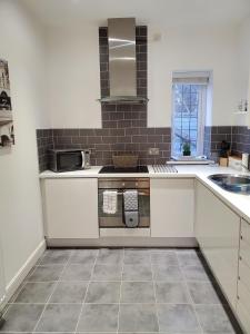 una cucina con piano cottura e lavandino di Purdis Farm - Flat 4 a Bucklesham