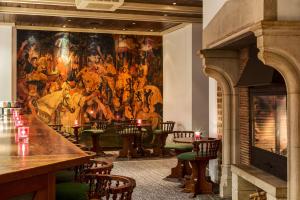 a bar with a large painting on the wall at NH Brugge in Bruges