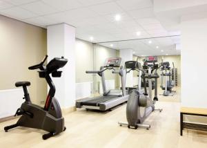 a gym with several tread machines in a room at NH Amsterdam Zuid in Amsterdam