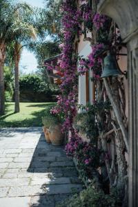 una pasarela con flores púrpuras en el lateral de una casa en Capo Santa Fortunata, en Sorrento