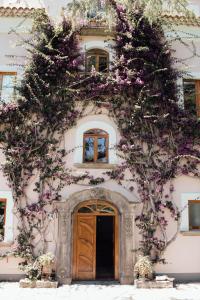 een gebouw met paarse bloemen aan de zijkant bij Capo Santa Fortunata in Sorrento