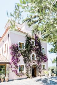 a white house with purple flowers on it at Capo Santa Fortunata in Sorrento