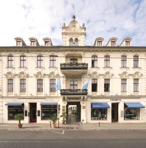 un gran edificio blanco con una torre de reloj en la parte superior en NH Potsdam, en Potsdam