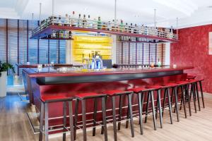 a bar with red bar stools in a restaurant at NH Potsdam in Potsdam