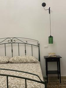een slaapkamer met een bed en een tafel met een lamp bij Il gallo di Eracle - Charming suites & rooms in Termini Imerese
