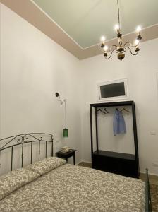 een slaapkamer met een bed met een blauw shirt aan de muur bij Il gallo di Eracle - Charming suites & rooms in Termini Imerese