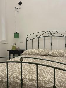 een slaapkamer met een bed met een metalen frame bij Il gallo di Eracle - Charming suites & rooms in Termini Imerese