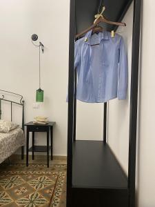 een blauw shirt op een rek in een slaapkamer bij Il gallo di Eracle - Charming suites & rooms in Termini Imerese