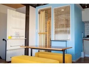 una mesa y dos sillas amarillas en una habitación en SHONAN garden - Vacation STAY 15108v, en Kamakura