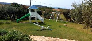 um parque infantil com um escorrega num quintal em Simos suites em Elafonisos