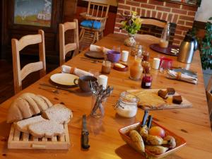 una mesa de madera con pan y otros alimentos. en Chambre d'hôtes Kerioret Izella, en Kerlaz