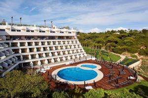 an external view of a hotel with a swimming pool at Tivoli Carvoeiro in Carvoeiro