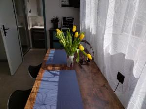 沙朗的住宿－Studio，花瓶上一张带黄郁金香的桌子