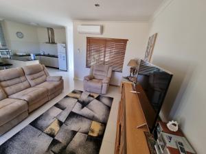a living room with a couch and a flat screen tv at Seafront Unit 25 in Jurien Bay