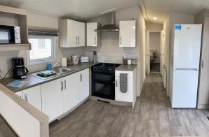 a kitchen with white cabinets and a white refrigerator at Seaview Holiday Rentals in Whitstable