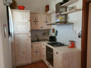 a kitchen with wooden cabinets and a stove top oven at Casetta Francy in San Teodoro