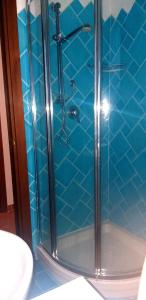 y baño con ducha y azulejos azules. en Casetta Francy, en San Teodoro