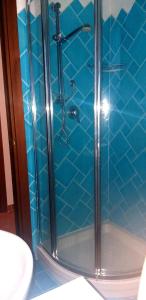 a bathroom with a shower with blue tile at Casetta Francy in San Teodoro +18 photos