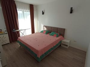 a bedroom with a bed with red sheets and a window at Adrianopol by the sea in Năvodari