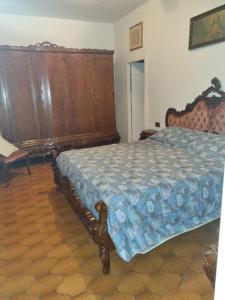 um quarto com uma cama e uma cabeceira em madeira em Casa giovanna em Rocca San Giovanni