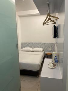 a small bedroom with a bed and a table at Coastline Hotel in Port Dickson +32 photos