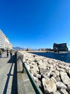 Un groupe de personnes marchant sur une jetée à côté de l'eau dans l'établissement SereMatte al 26, à Naples