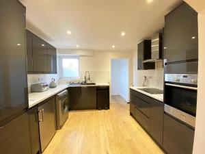 uma cozinha com electrodomésticos pretos e piso em madeira em Freshly renovated 2 bedroom Victorian town house. em Hereford