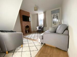 uma sala de estar com duas cadeiras e um sofá em Freshly renovated 2 bedroom Victorian town house. em Hereford