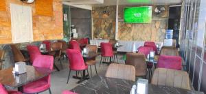 a restaurant with pink chairs and tables in a room at Didim Elit Otel in Didim