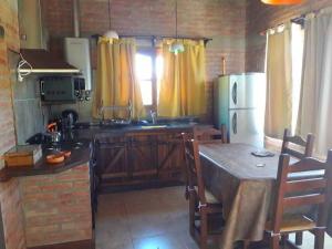 a kitchen with a table and a refrigerator at Altos de San Blas in San Javier