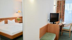 a hotel room with a bed and a tv at Landhotel Günzburg in Kupferzell