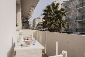 een balkon met een tafel en een palmboom bij IN CENTRO E AL MARE - CASA CON TERRAZZO E NETFLIX in Cattolica