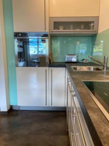 a kitchen with white cabinets and a sink at Mountain View Apartment in Maria Alm am Steinernen Meer