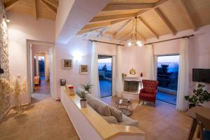 un soggiorno con divano e camino di Villa Belvedere Rosa a Tsoukalades