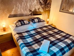 a bedroom with a plaid bed with two pillows at Naturepark Resort in Harrachov