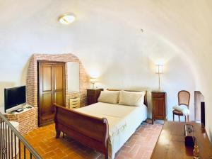 a bedroom with a bed and a couch and a television at Maidalchini House in Acquapendente