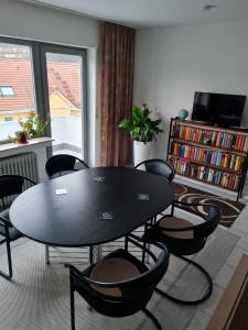 a table and chairs in a room with a book shelf at Fränkische Rhön Wohnung mit Bergblick ツ in Bad Kissingen