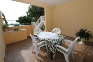 a patio with a table and chairs on a balcony at Apartments Ana - Kustići in Novalja