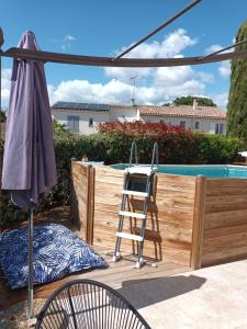 uma escada e uma cadeira ao lado de uma piscina em Jolie petite suite Côte d'Azur. em Fréjus