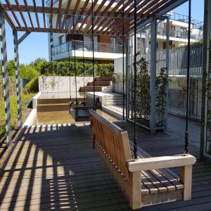 weranda z huśtawką i budynkiem w obiekcie JPapartments Nadmorski Park w Gdańsku