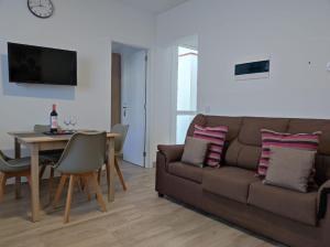 una sala de estar con un sofá y una mesa en CASA PIRÁMIDE 3. Terraza WiFi y Parking Privado, en Icod de los Vinos
