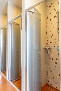 La salle de bains est pourvue de 2 miroirs et d'un mur en pierre. dans l'établissement Intra Muros Hostel, à Héraklion