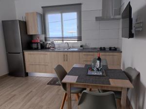 uma cozinha com uma mesa com cadeiras e um frigorífico em CASA PIRÁMIDE 3. Terraza WiFi y Parking Privado em Icod de los Vinos