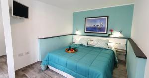 Un dormitorio con una cama azul con un tazón. en Casa al mare Orchidea en Cala Gonone