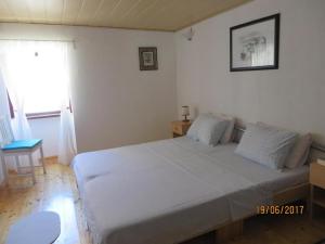 Un dormitorio con una gran cama blanca y una ventana en Zora Holiday home en Beli