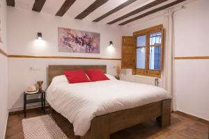 a bedroom with a large bed with red pillows at CUENCALOFT EL CASTILLO in Cuenca