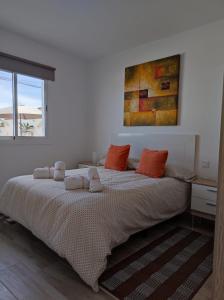 um quarto com uma cama grande e almofadas laranja em CASA PIRÁMIDE 3. Terraza WiFi y Parking Privado em Icod de los Vinos