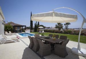 a table with chairs and an umbrella next to a pool at Fantastic renovated villa annex in Mijas Costa