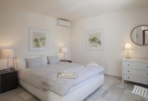 a bedroom with a bed with two lamps and a mirror at Fantastic renovated villa annex in Mijas Costa +33 photos