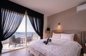 a bedroom with a bed with a view of a balcony at Blue lake luxury villa for families in ‘Ein el Asad +7 photos
